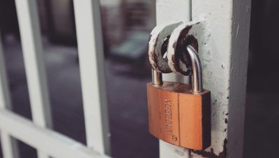 Closeup of a rusty padlock on a metal gate providing security and protection.