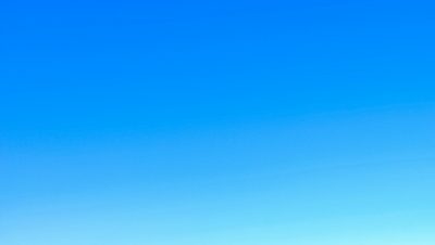 A serene view of a vibrant clear blue sky with a subtle gradient, perfect for backgrounds.