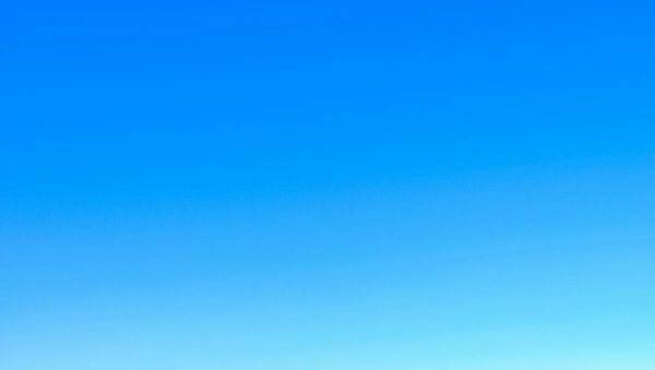 A serene view of a vibrant clear blue sky with a subtle gradient, perfect for backgrounds.