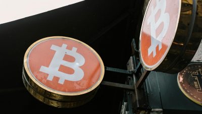 Close-up view of outdoor bitcoin symbol signs, reflecting modern cryptocurrency trends.